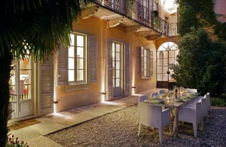Table and chairs outside house with open windows