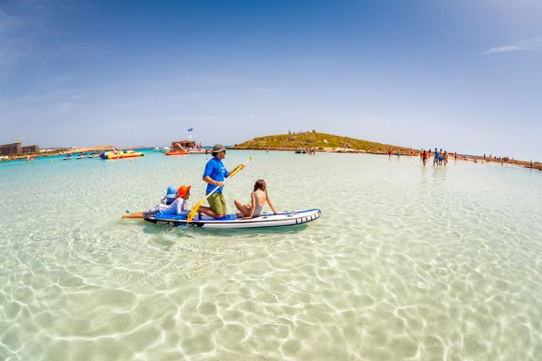 Father With Kids Having Fun On Stand Up Paddle Board At Nissi Beach