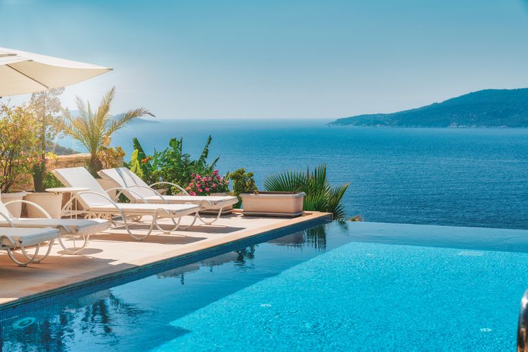 Veranda Decorated With Deck Chairs And Umbrella With An Ocean View
