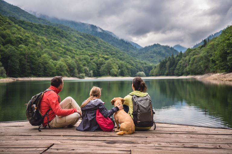 Family With Dog Resting On A Pier