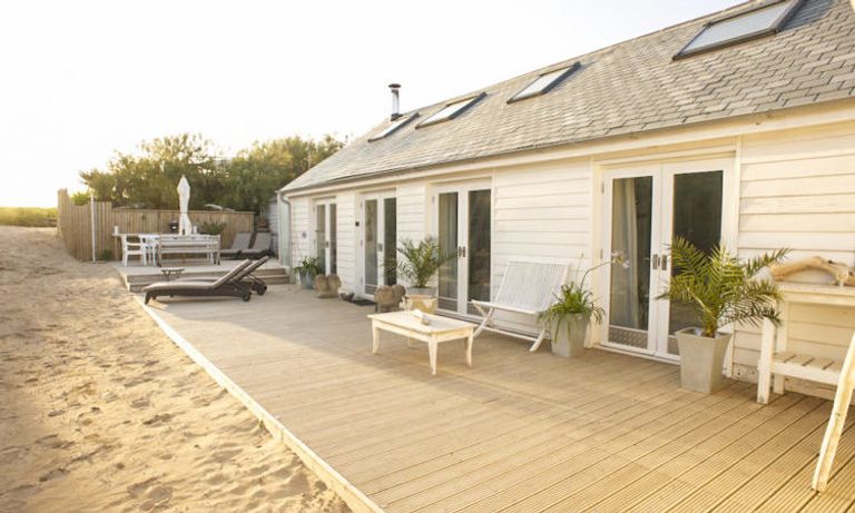 Cream cottage on the sand at dusk - Sandcrest Cottage in Cornwall