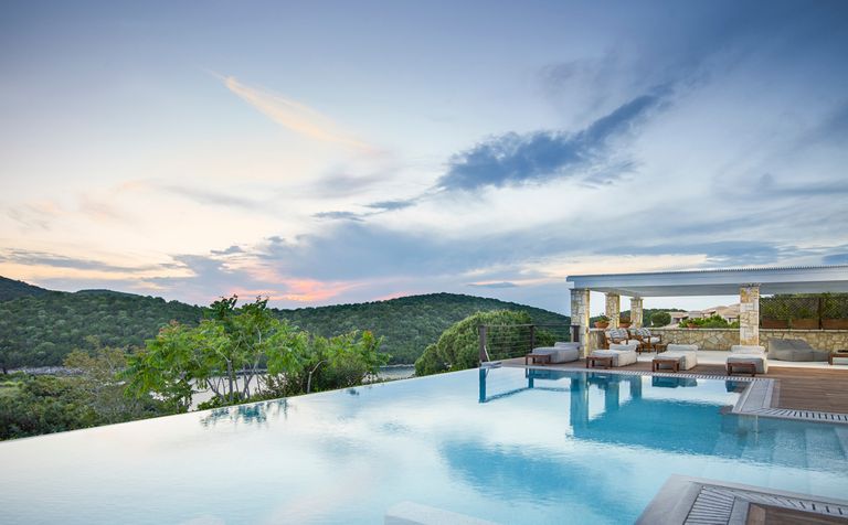 Infinity pool with view of mountain at sunset