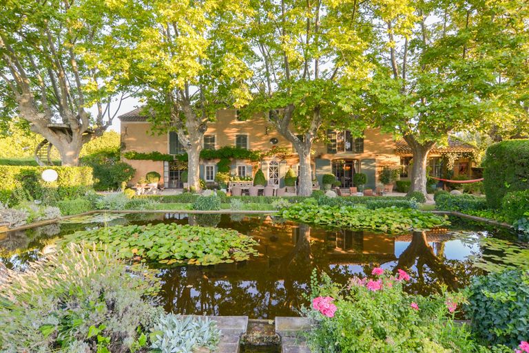 pretty house with a pond and greenery